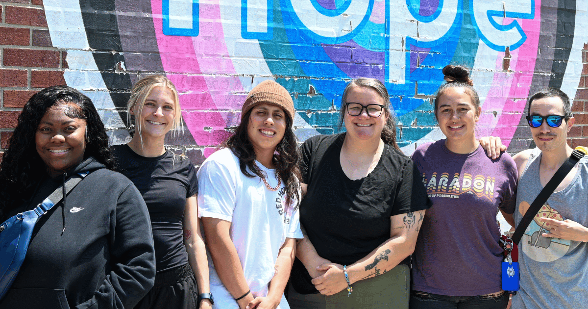 Class 1 Teaching Staff standing together in front of the Hope mural